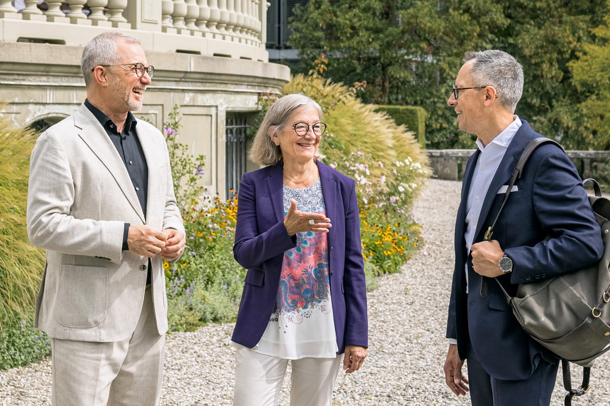 3 Menschen im Garten eines antiken Gebäudes, Patrick Rohr, Sanjay Singh, stellvertretender CEO bei der CSS, und FMH-Präsidentin Yvonne Gilli